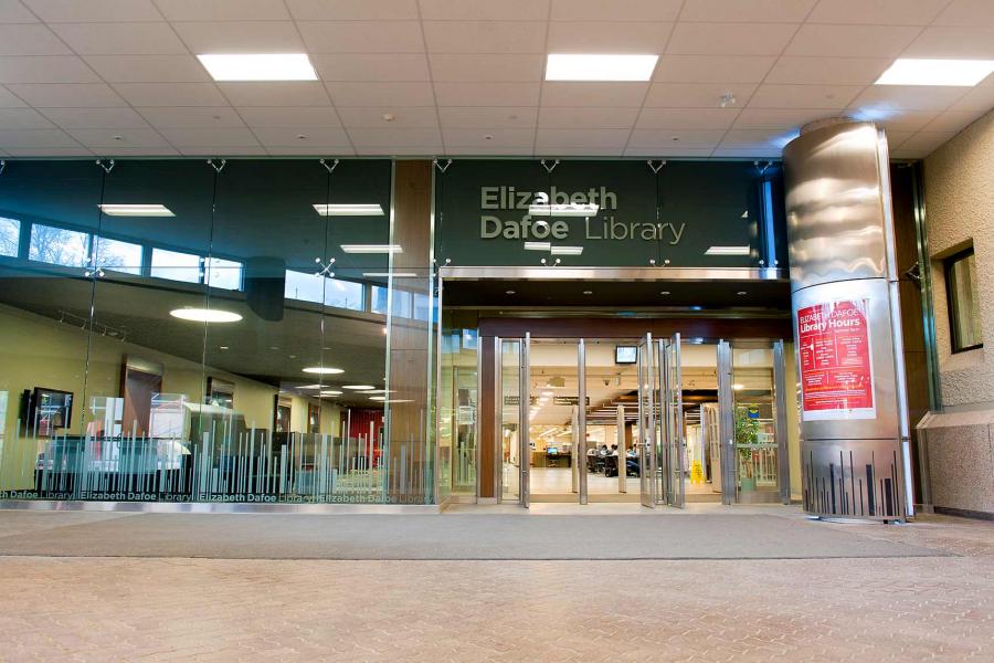 Glass wall and open doors below a sign reading Elizabeth Dafoe Library.