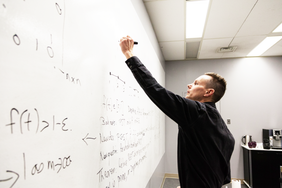 Steve Low writing an equation on the board.