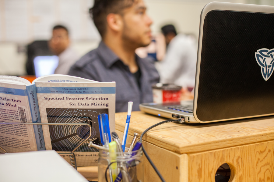 Data Mining student with textbook open listening to lecture