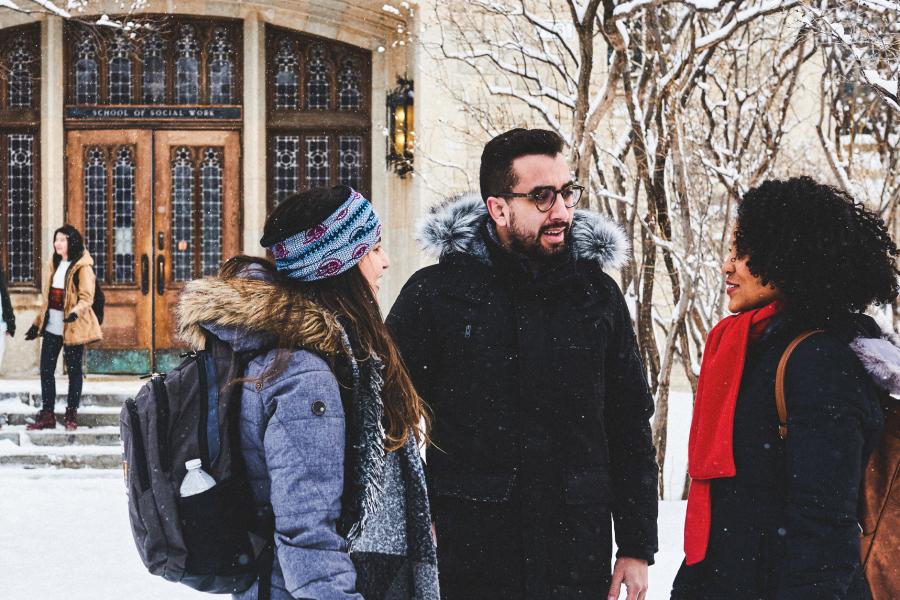 Three students talking outdoors on Fort Garry campus during winter