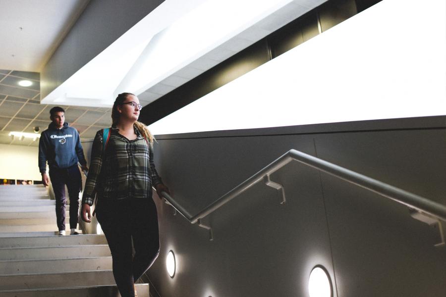 Student walking down the stairs in the Art Lab building.