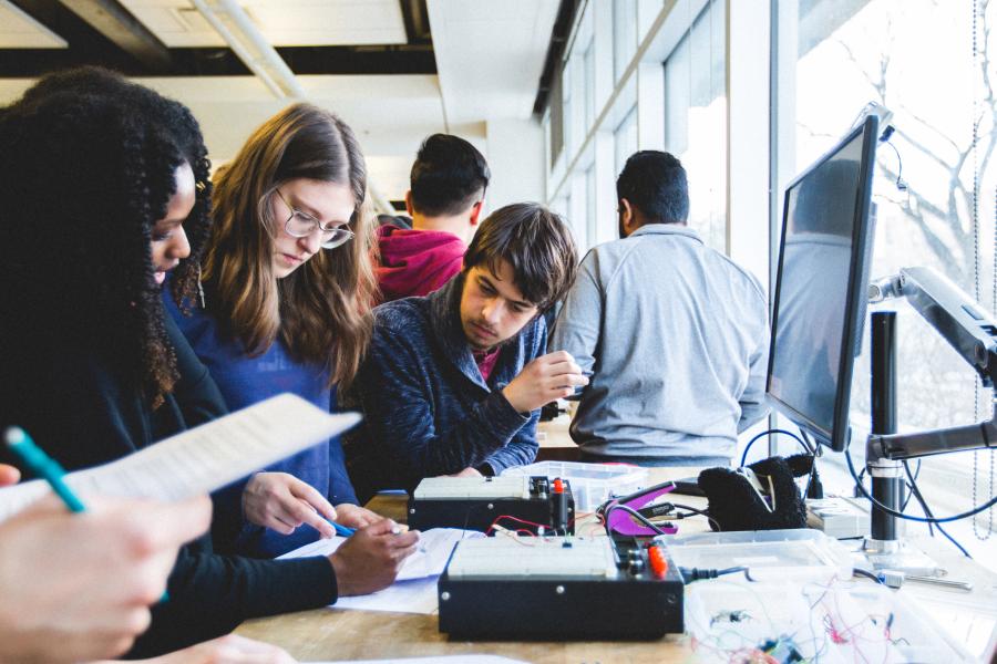 An image of a group of three students concentrating on a task.