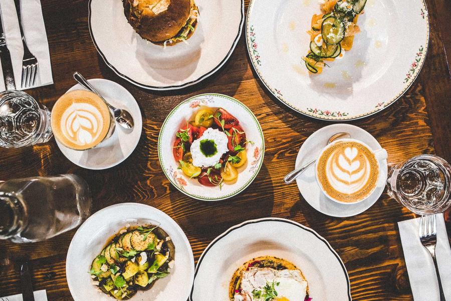 A spread of dishes including avocado toast, eggs, and a burger, from Clementine Cafe.