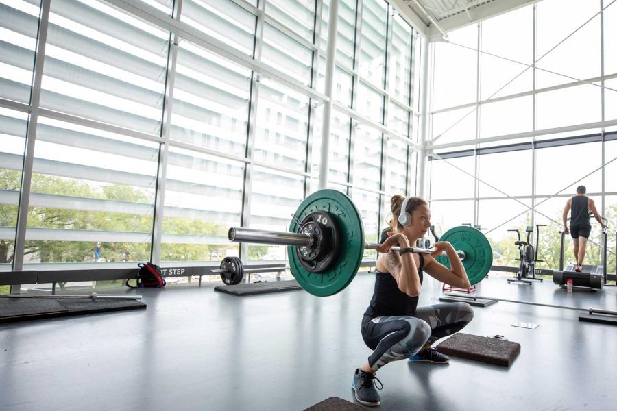 A young woman lifting a barbell at the Active Living Centre.