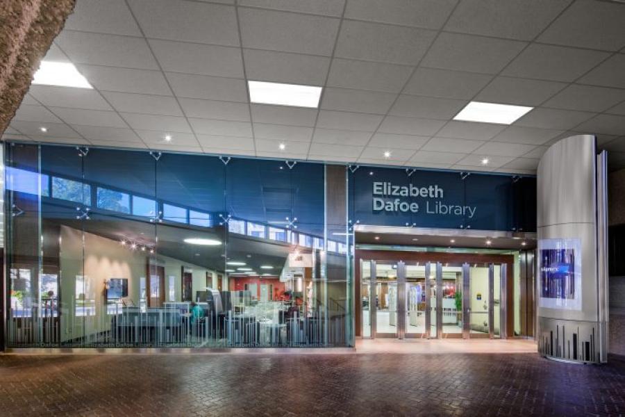 The entryway to the Elizabeth Dafoe Library shows a glass wall and four glass doors leading inside.