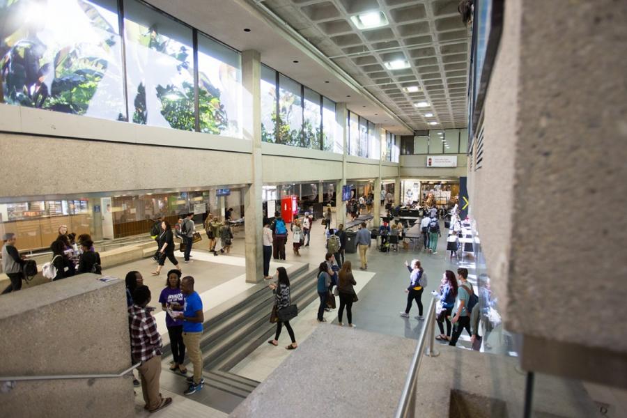 Many people standing and walking through the first floor area of the UMSU University Centre.
