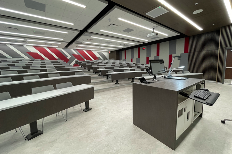 Large classroom at the Asper School of Business with more than 10 rows of long desks and large chevrons painted on the back wall.