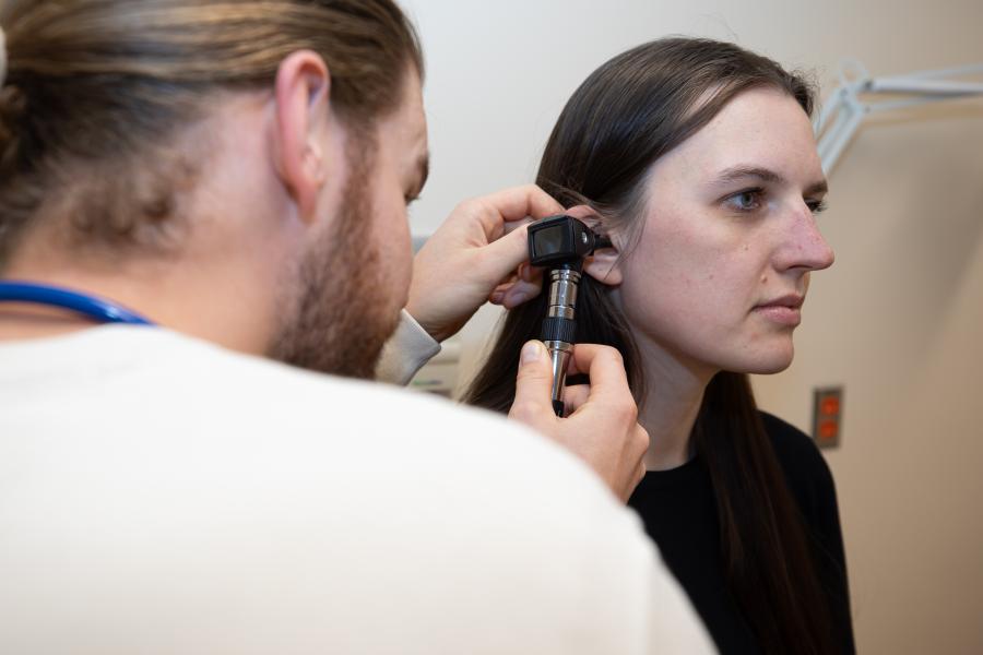 Student examines mock patients ear