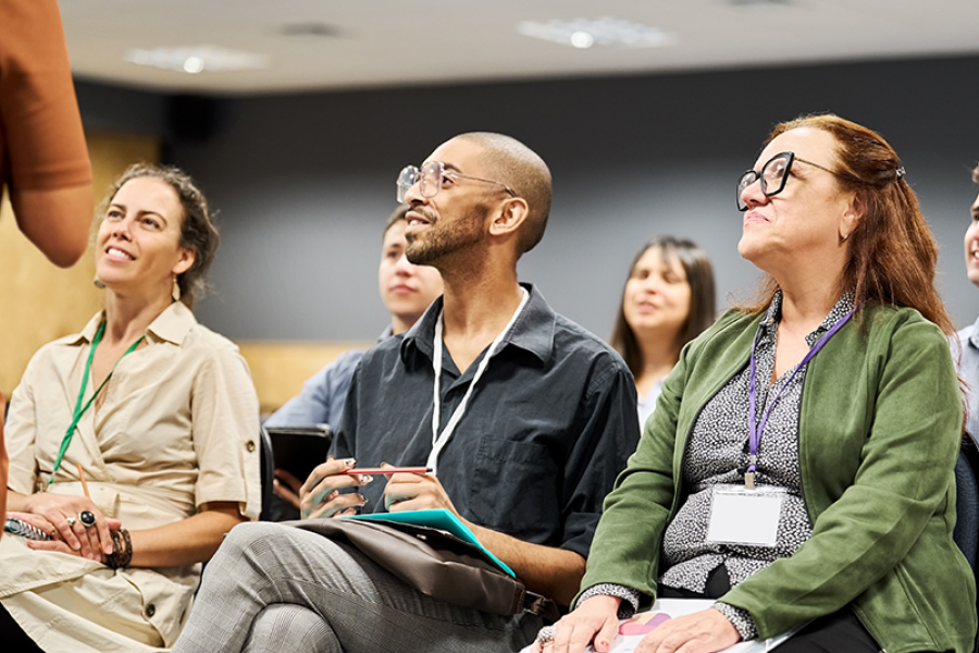 Multiracial group of people listening to a speaker during a conference event at convention center