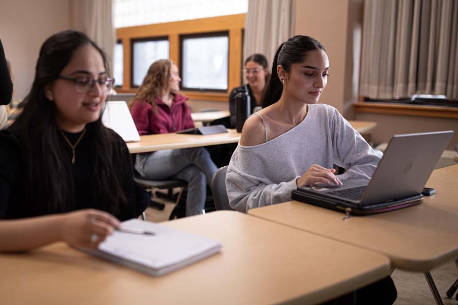 Students seated in a classroom, taking notes.