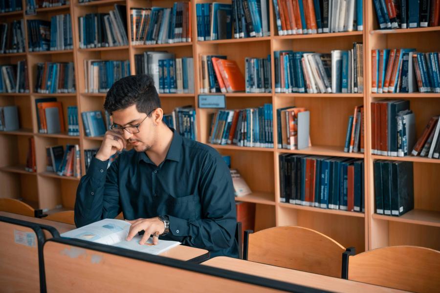 A person reading a book in the library.