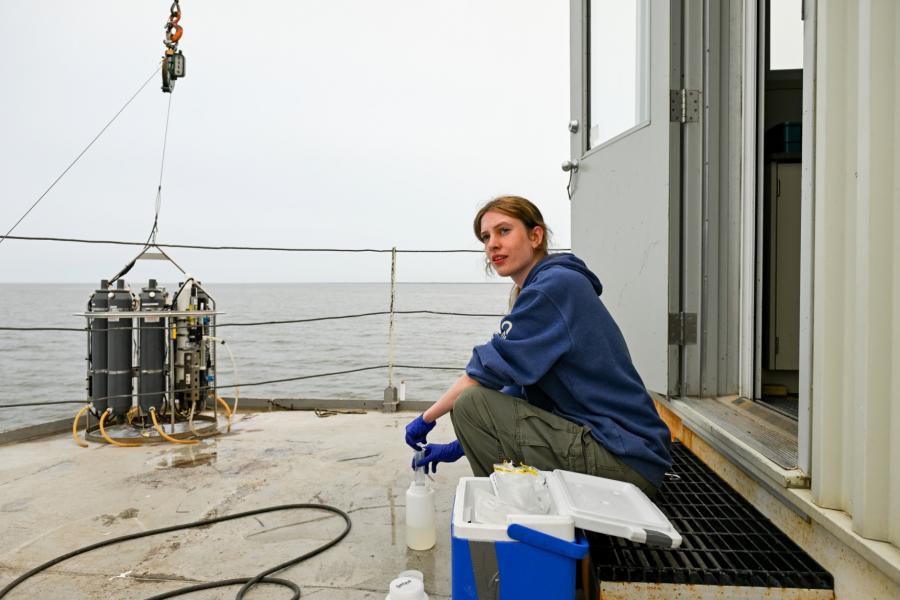 A student seals a cap of sample water on a boat on Lake Winnipeg.