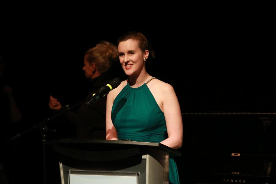 Desautels music student addressing a crowd from a podium at an event