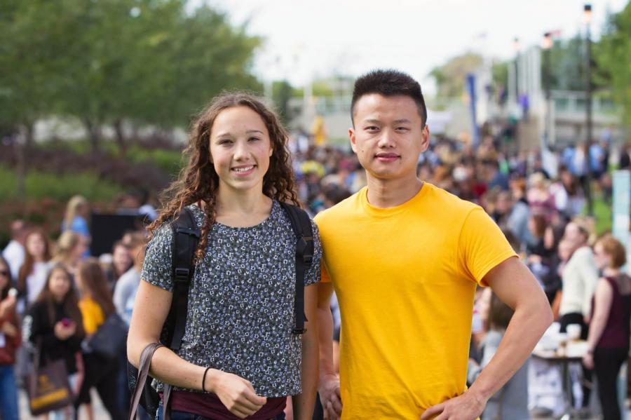 Two University of Manitoba students stand side by side outdoors at an orientation event.
