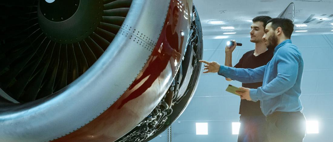 Aircraft maintenance engineer examines plain engine