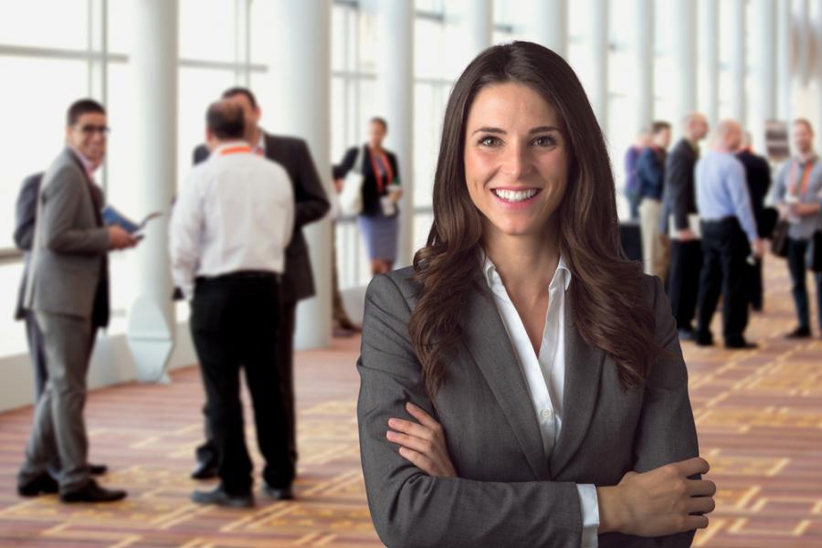 professional women posing in conference room with networking behind her