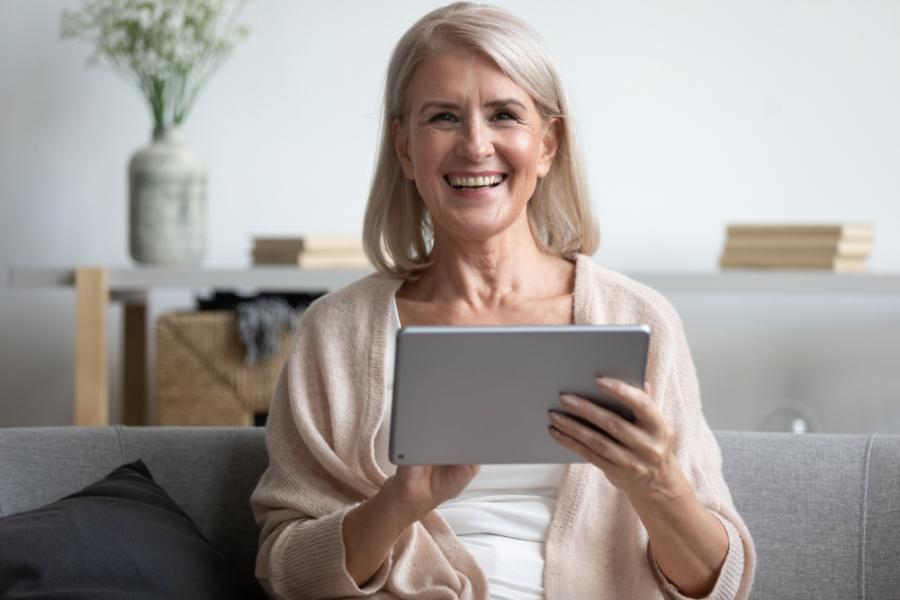 confident smiling older woman holding a tablet