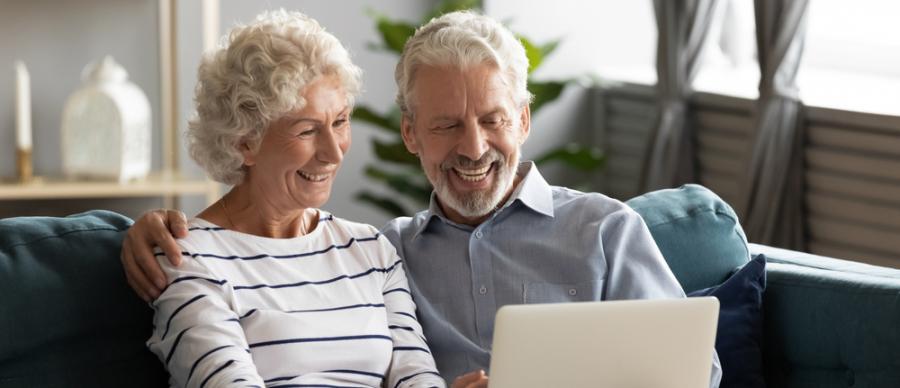 smiling older couple working on a laptop