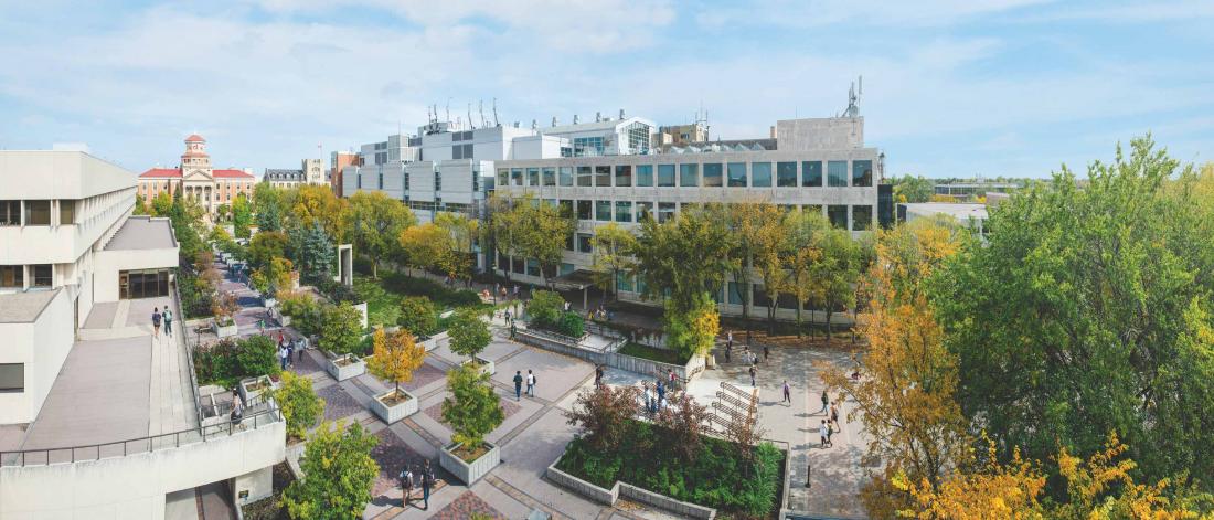 Aerial view of Fort Garry campus showing the tree-lined Currie Pedway and the Administration Building in the background.