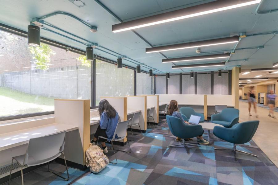 Rendering of learning space featuring study carrels and group seating around a low table.