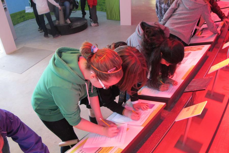 Students lean on the exhibits in FFDC completing a worksheet during an educational program. 