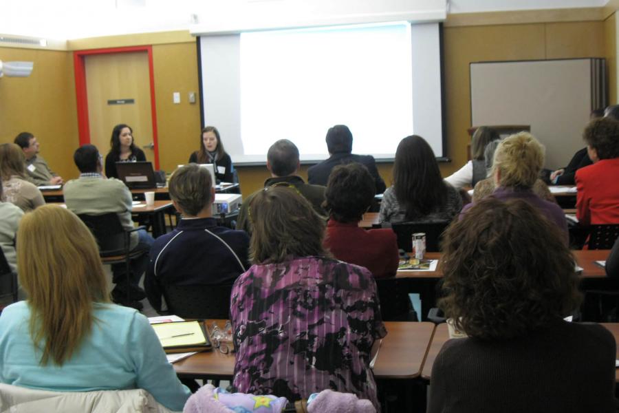 A large group of people take part in a lecture style conference at FFDC.