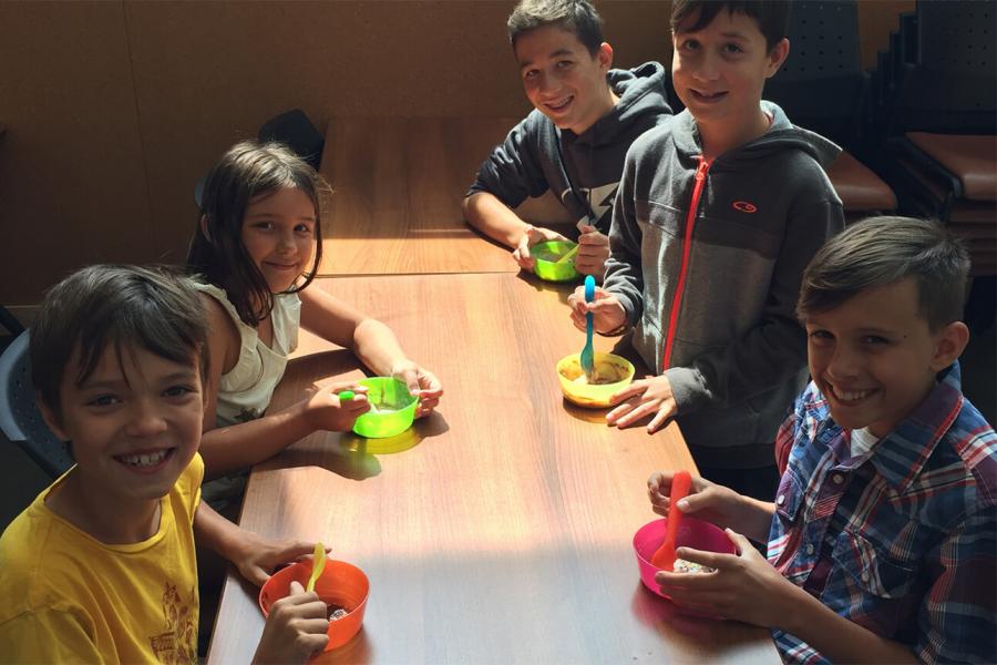 A group of 5 kids enjoy the fresh ice cream they just made at FFDC during a birthday party.