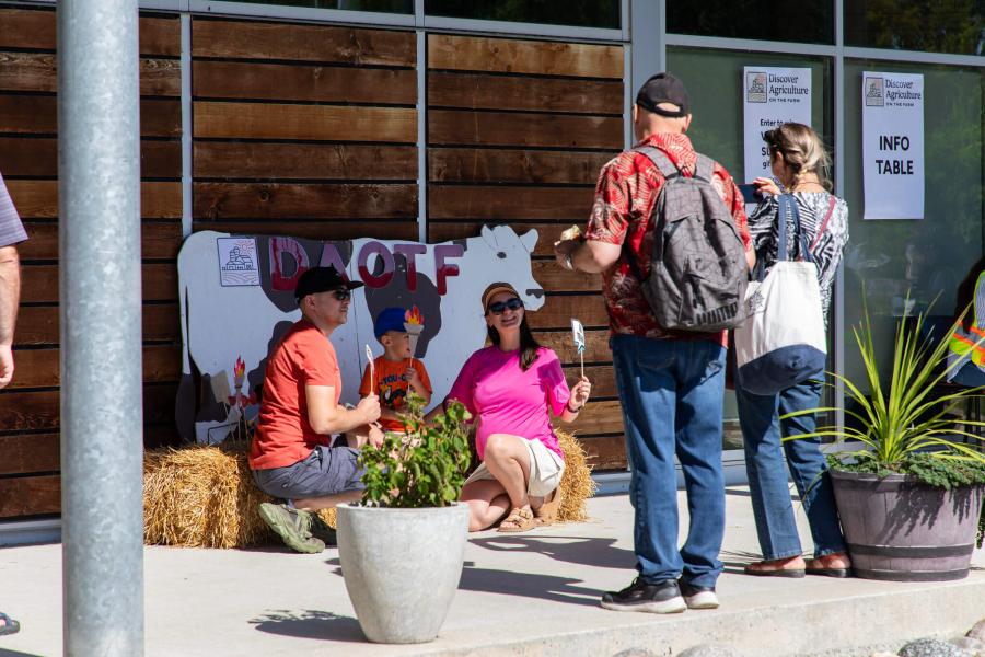 Visitors pose for pictures in front of a cow cut out