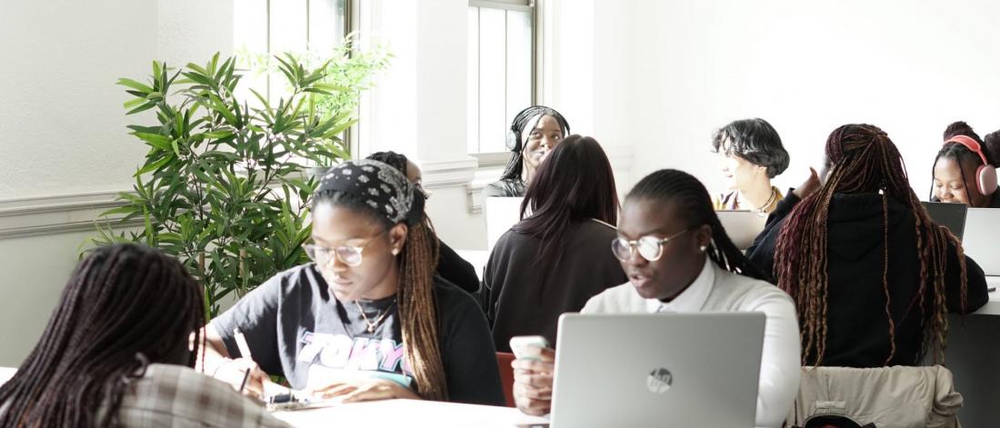 students studying at tables in a brightly lit space