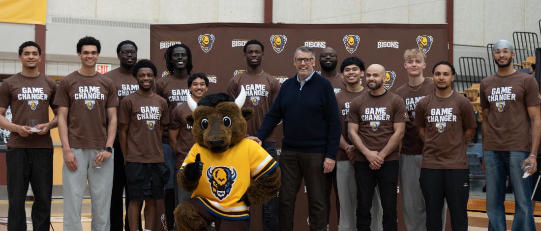 John Loewen with Billy the Bison and the men's basketball team