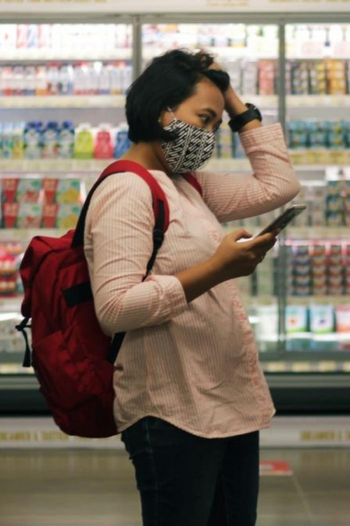 Student looking worried while shopping at a grocery store.