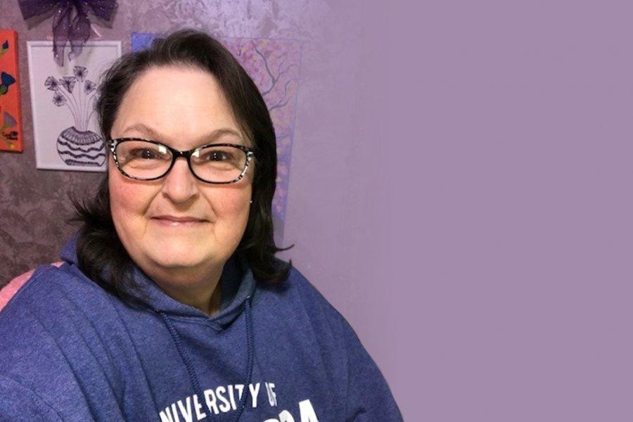 A portrait photo of Carol Schlamb with a purple background.