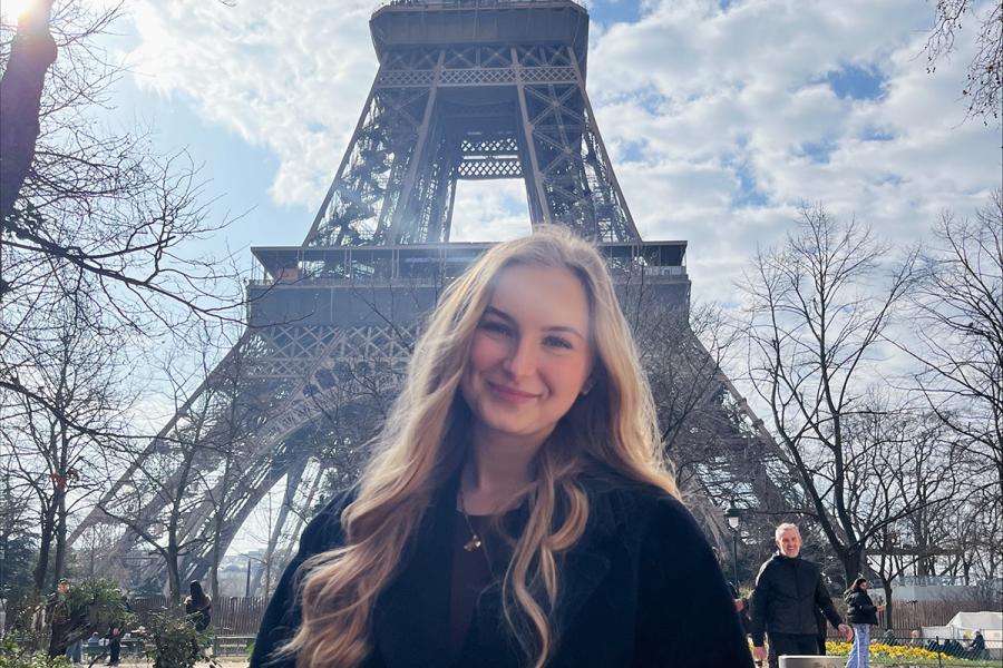 Melisa Miljkovic standing in front of the Eiffel Tower.