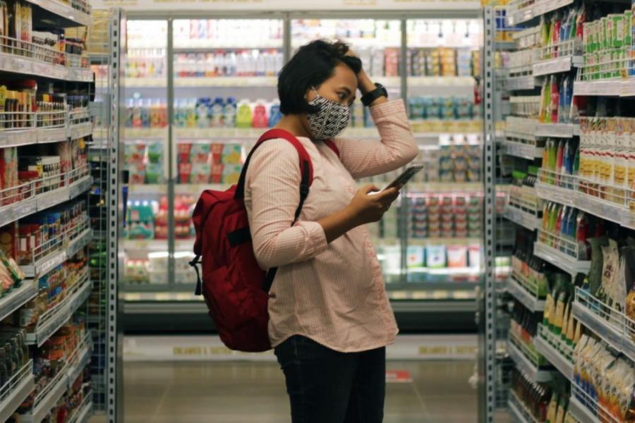 Student looking worried while shopping at a grocery store.