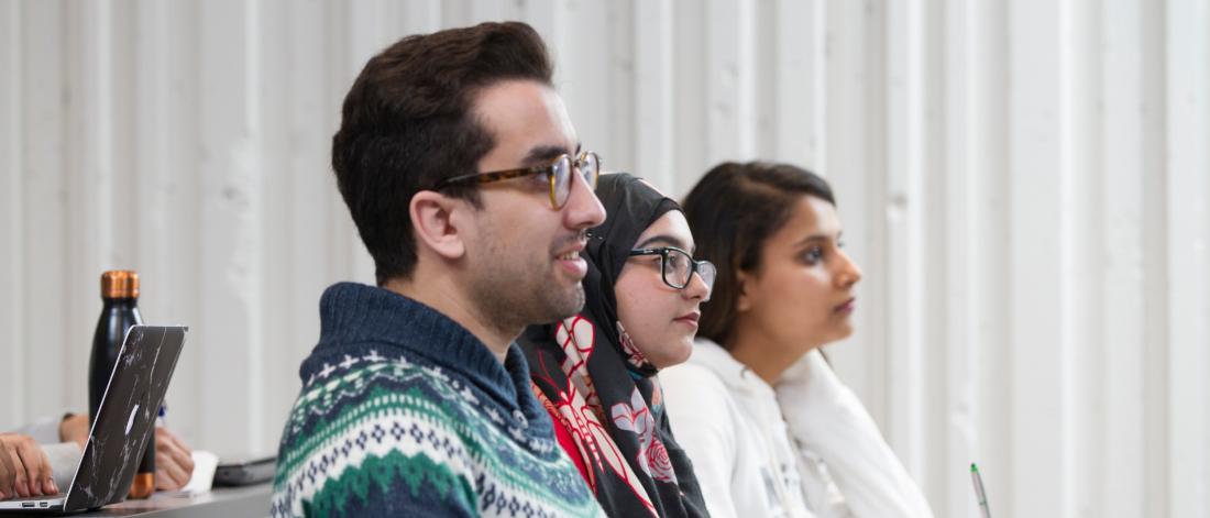 Graduate Students sat in class listening to a presentation.