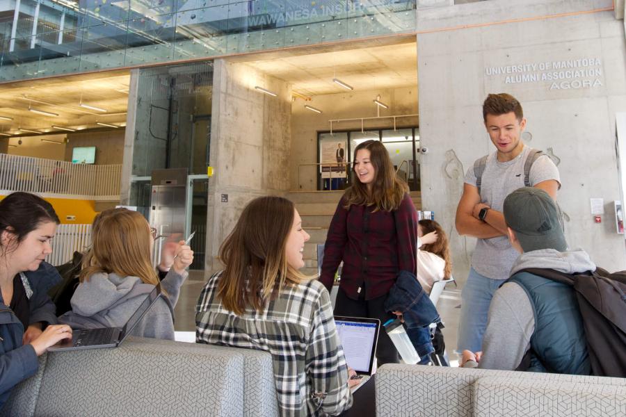 A group of seven students hanging out and studying together inside the Active Living Centre.