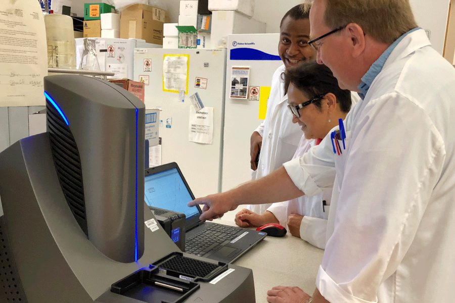 Students in the Apotex Immunology Lab look at data on a computer.