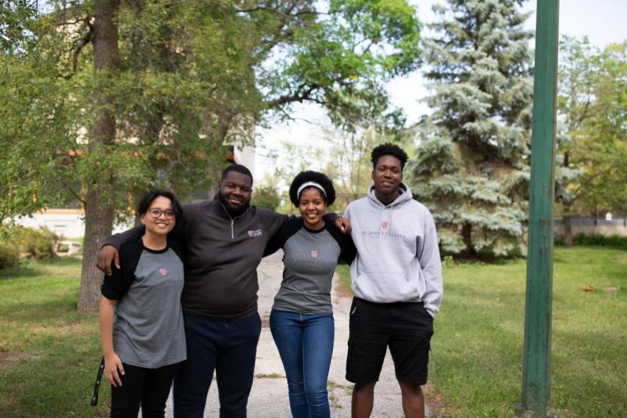 Four students, arm in arm, outside of St. John's College.