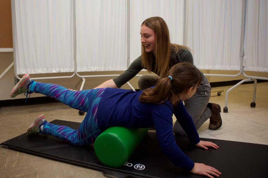 A physical therpist working with a youth patient.