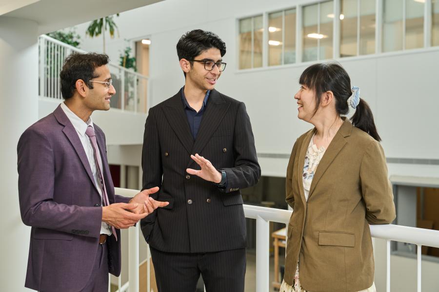 A group of three people standing and talking.