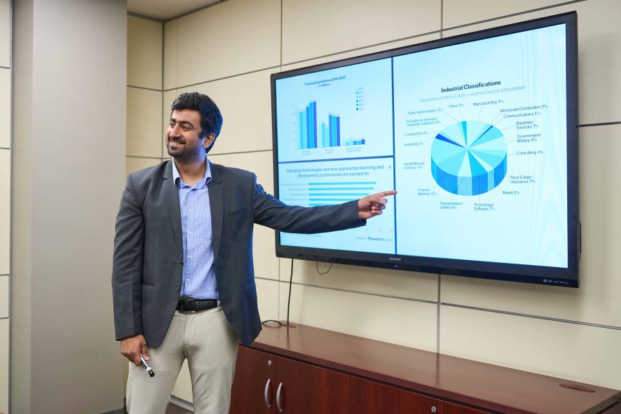 A post doctoral fellow presenting to a classroom.
