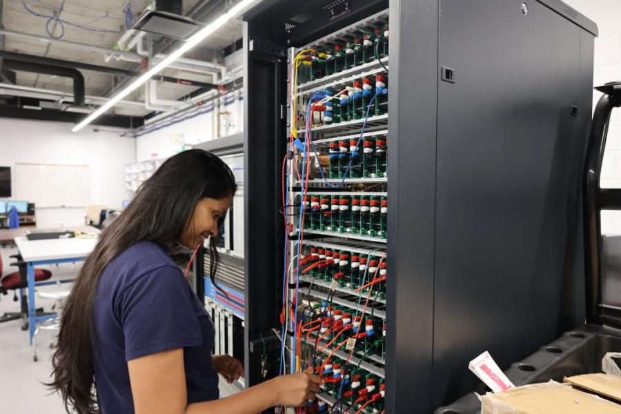 Female student working on a computer panel.