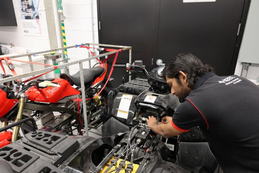 Student doing electrical work in vehicle.