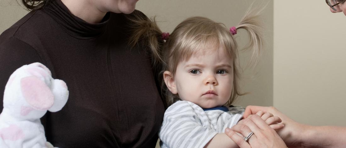 Close up image of a child sitting on an adults lap.