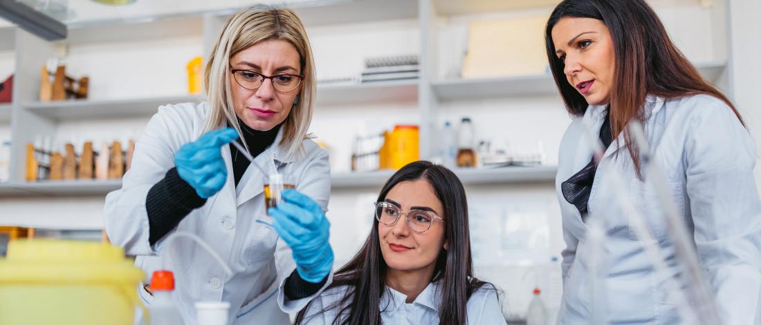 Three women conducting research in a basic sciences lab.