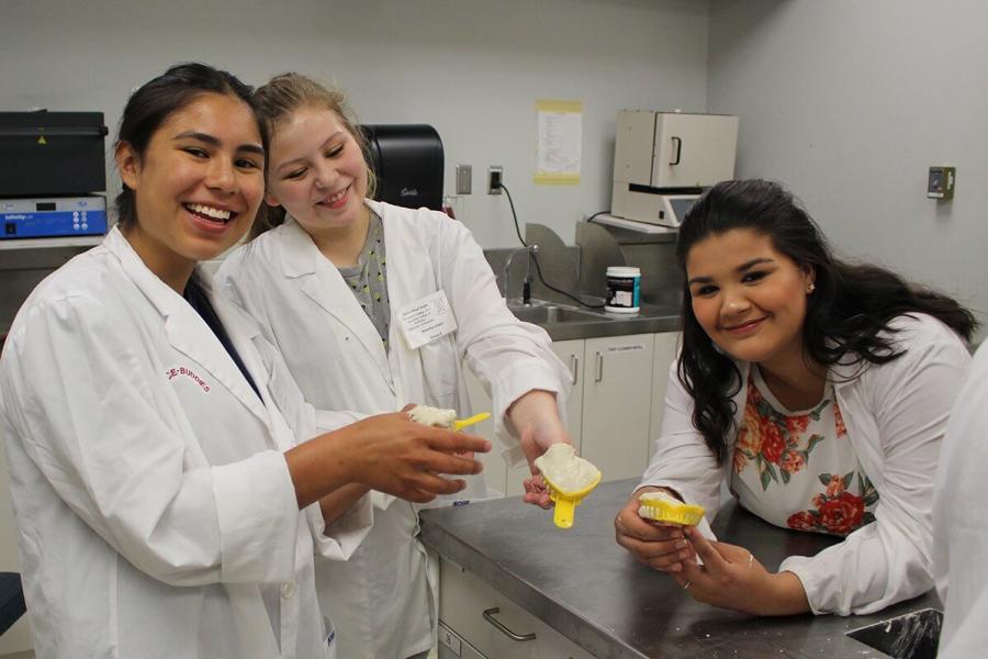 Participants in the biomedical youth program showing off dental casts.