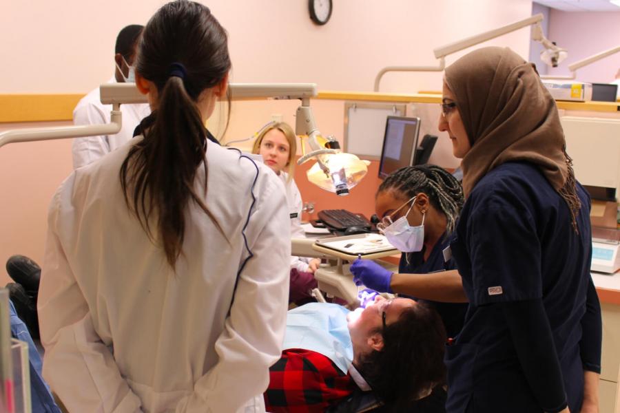 Students from the dentistry, dental hygiene and nurse practitioner programs assessing patients together as part of a project.
