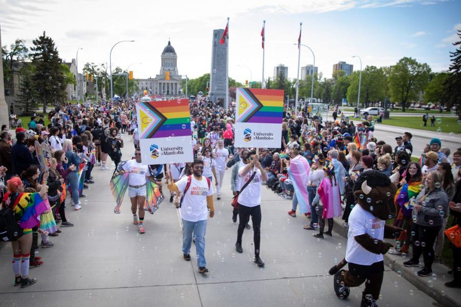 People watching a Pride celebration parade.