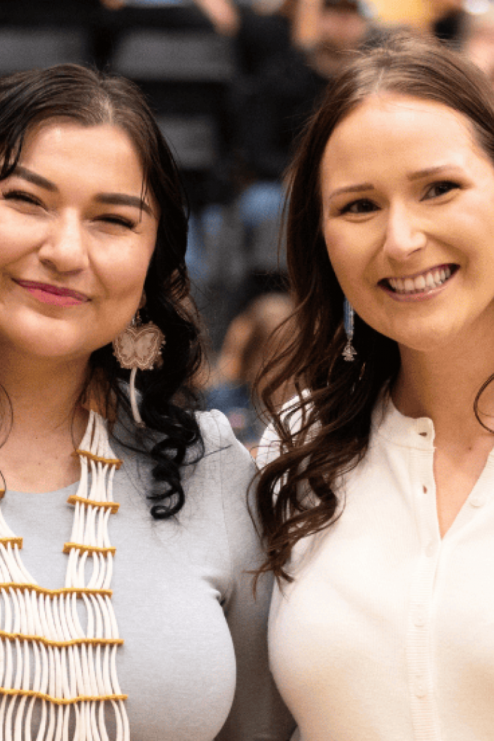 A nominee and award recipient stand together and smile during a ceremony.