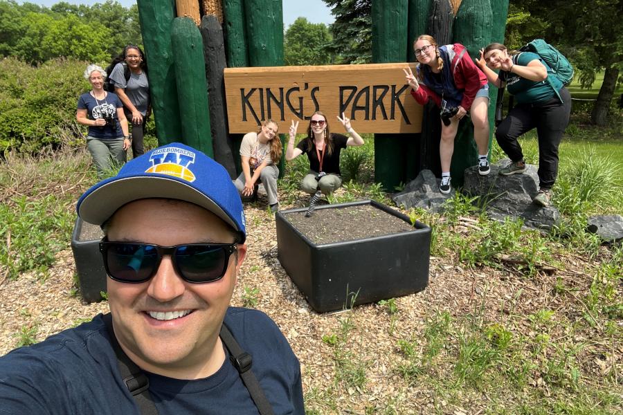 several people that went birding standing in front of the King's Park sign